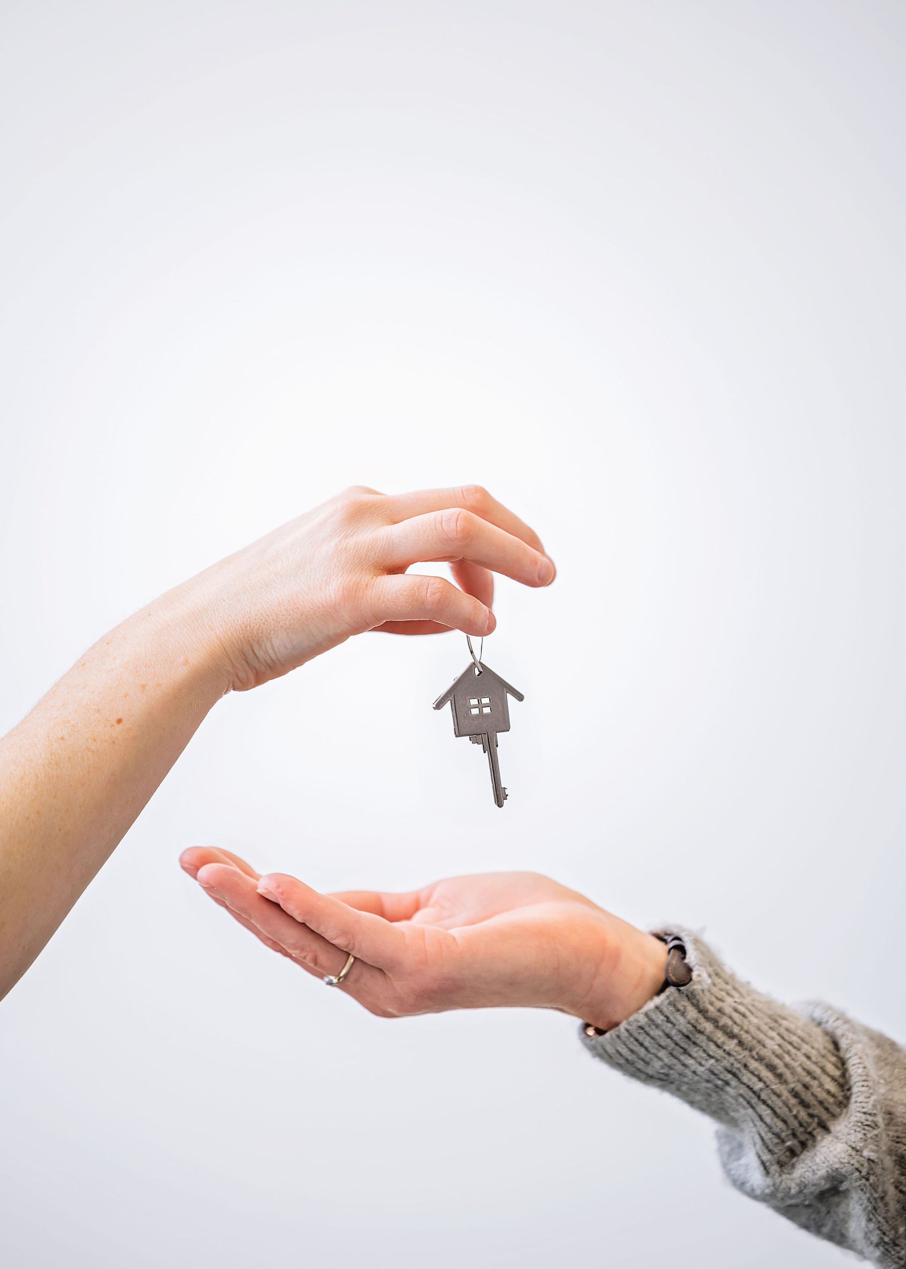 A set of house keys handed from one person to another