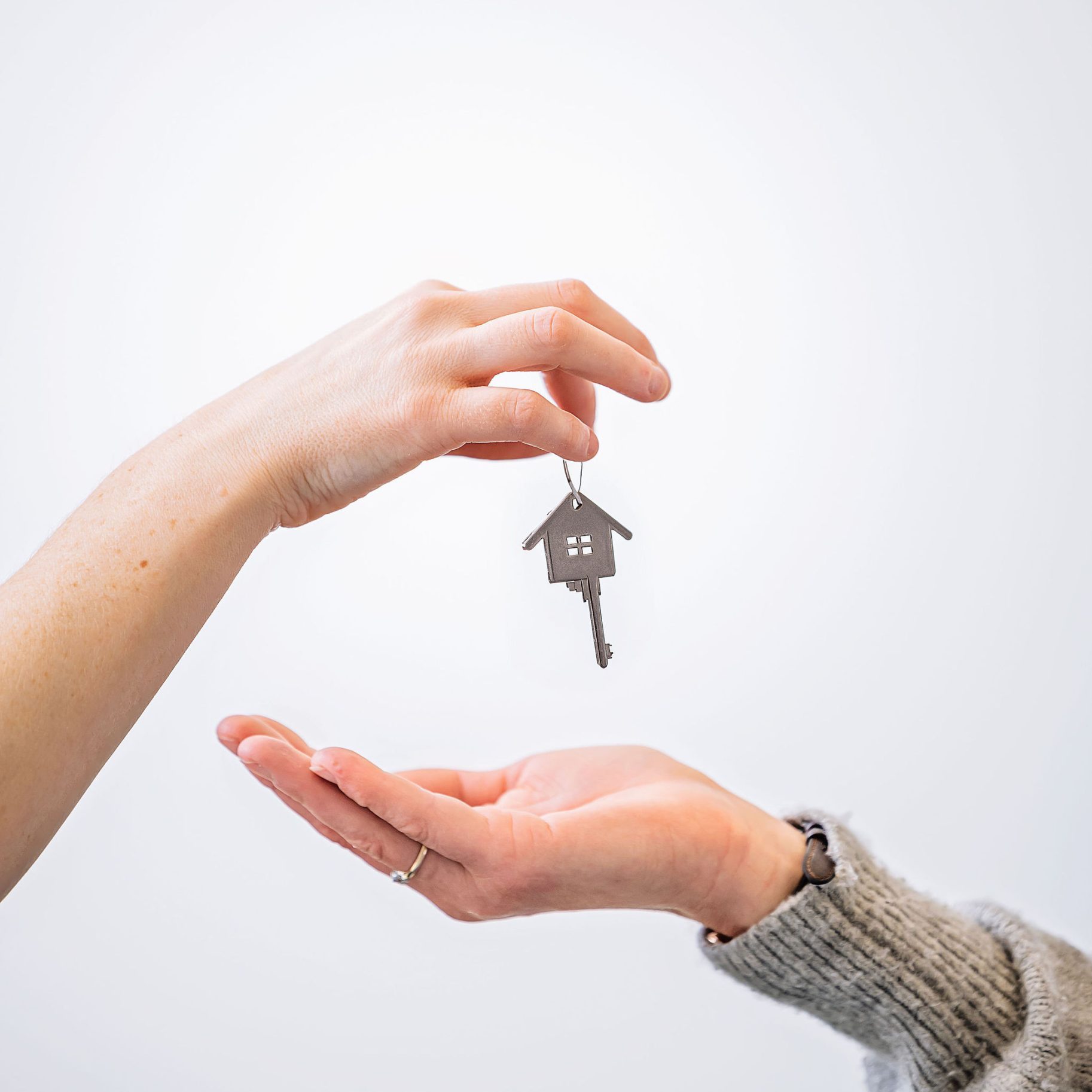 A set of house keys handed from one person to another